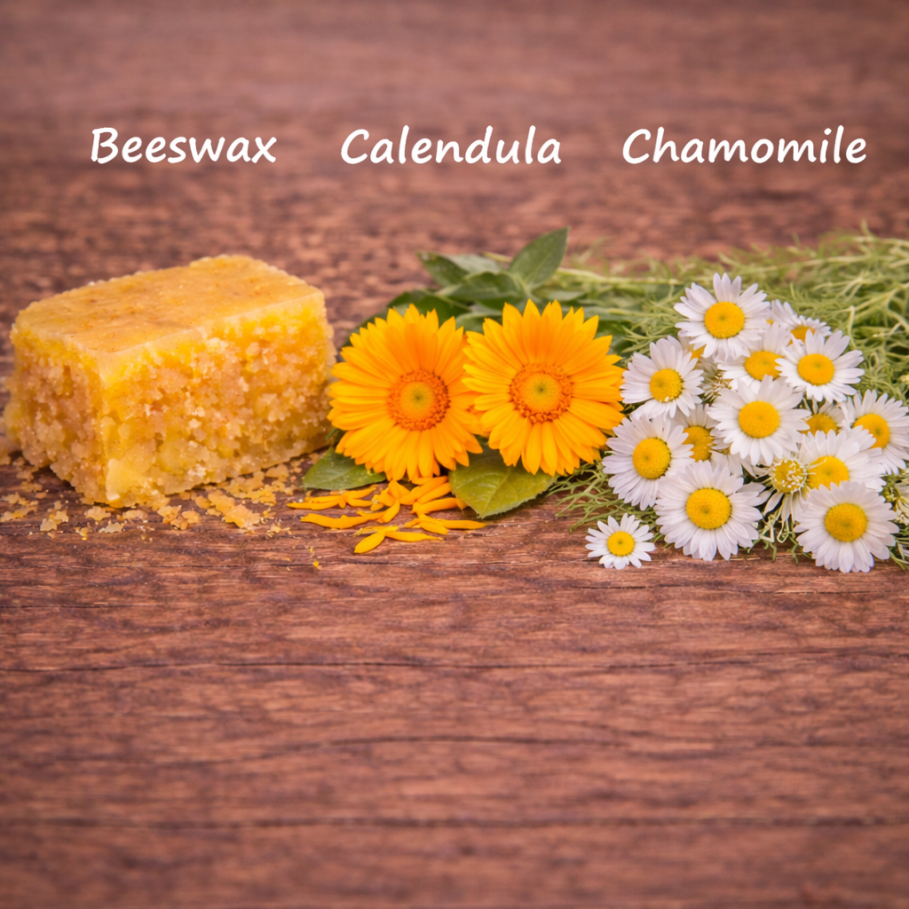 Beeswax block with calendula and chamomile flowers on a wooden background