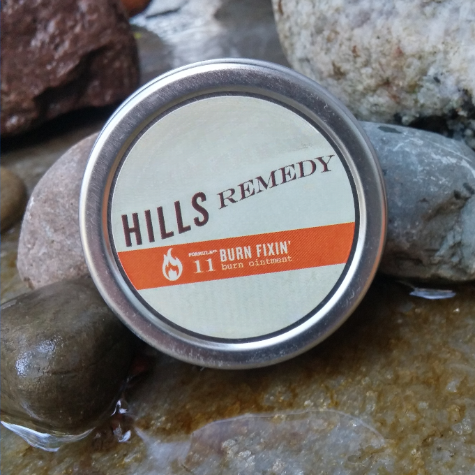 Tin labeled 'Hills Remedy' on a stone surface