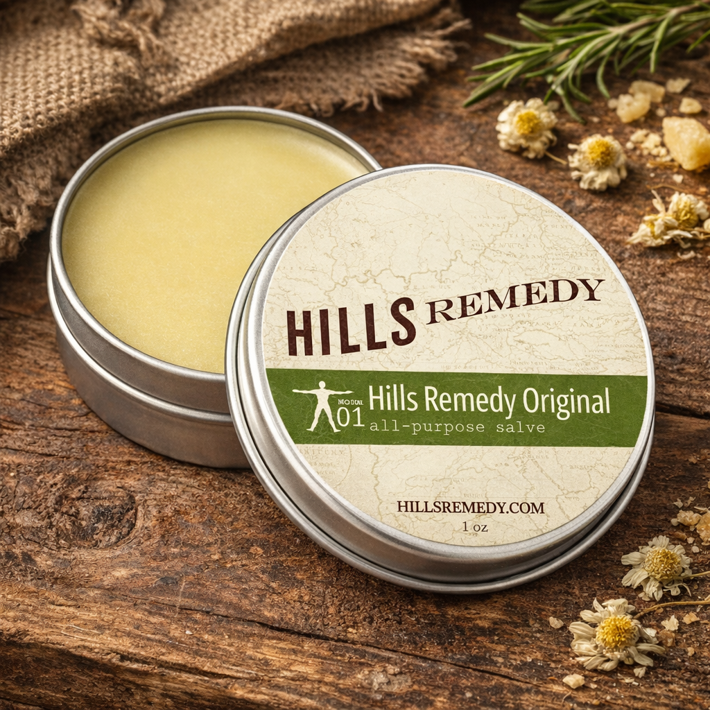 Hills Remedy all-purpose salve tin on a wooden surface with herbs and flowers.